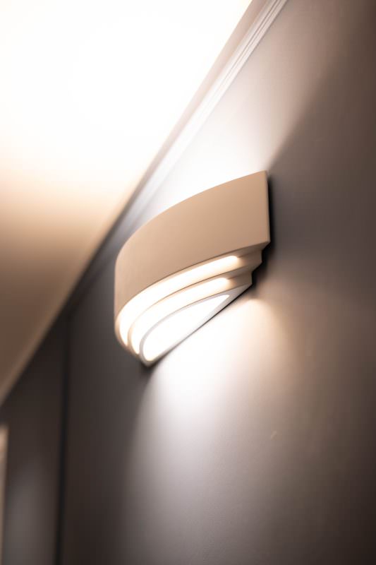 Dettaglio di un'applique a parete che diffonde una luce calda