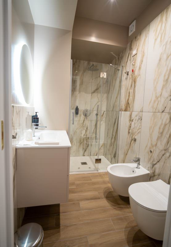 Bagno in marmo con doccia a pioggia e mobile lavabo sospeso