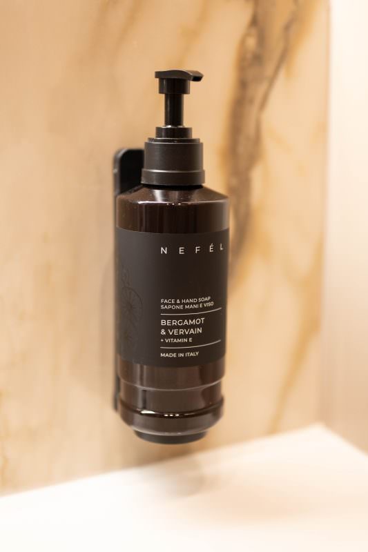 Dispenser di sapone per mani e viso a parete nel bagno in marmo